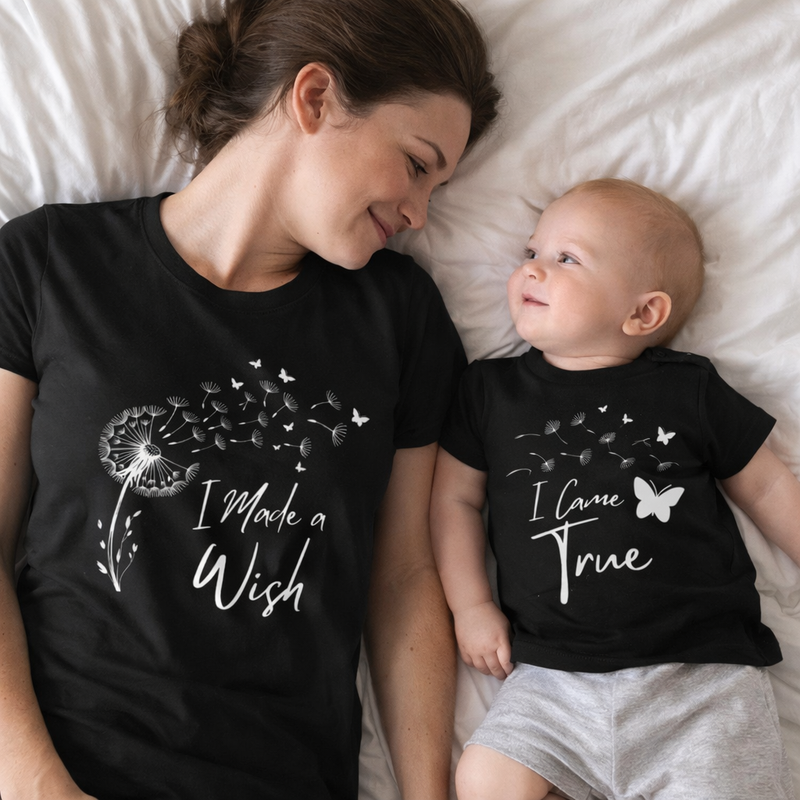 Woman and baby wearing matching black t-shirts with white text and graphics.